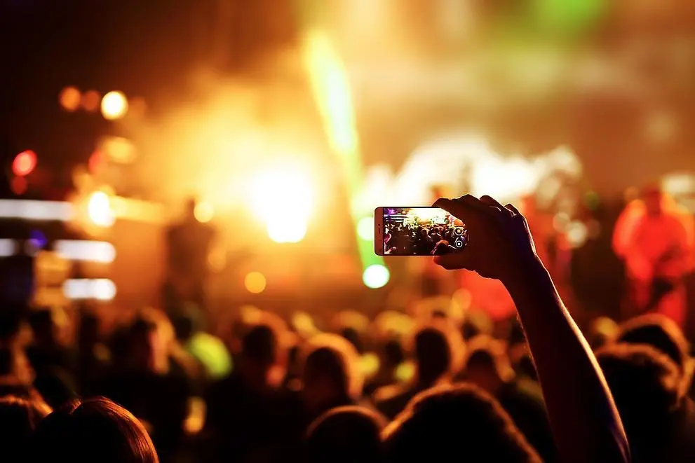 Person som filmar med mobiltelefon vid konsert
