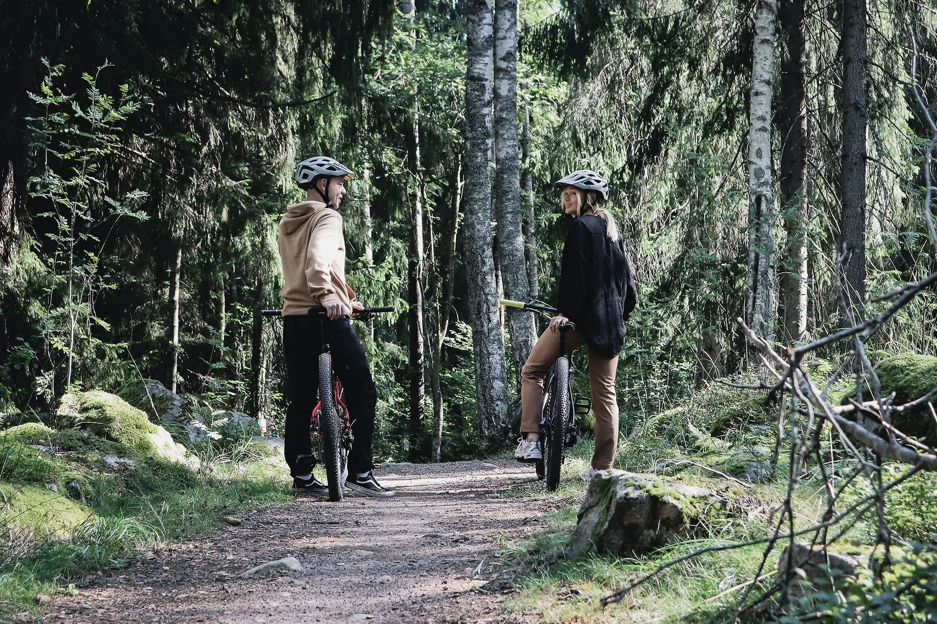 Två personer som tar en rast från cyklingen på en skogsväg