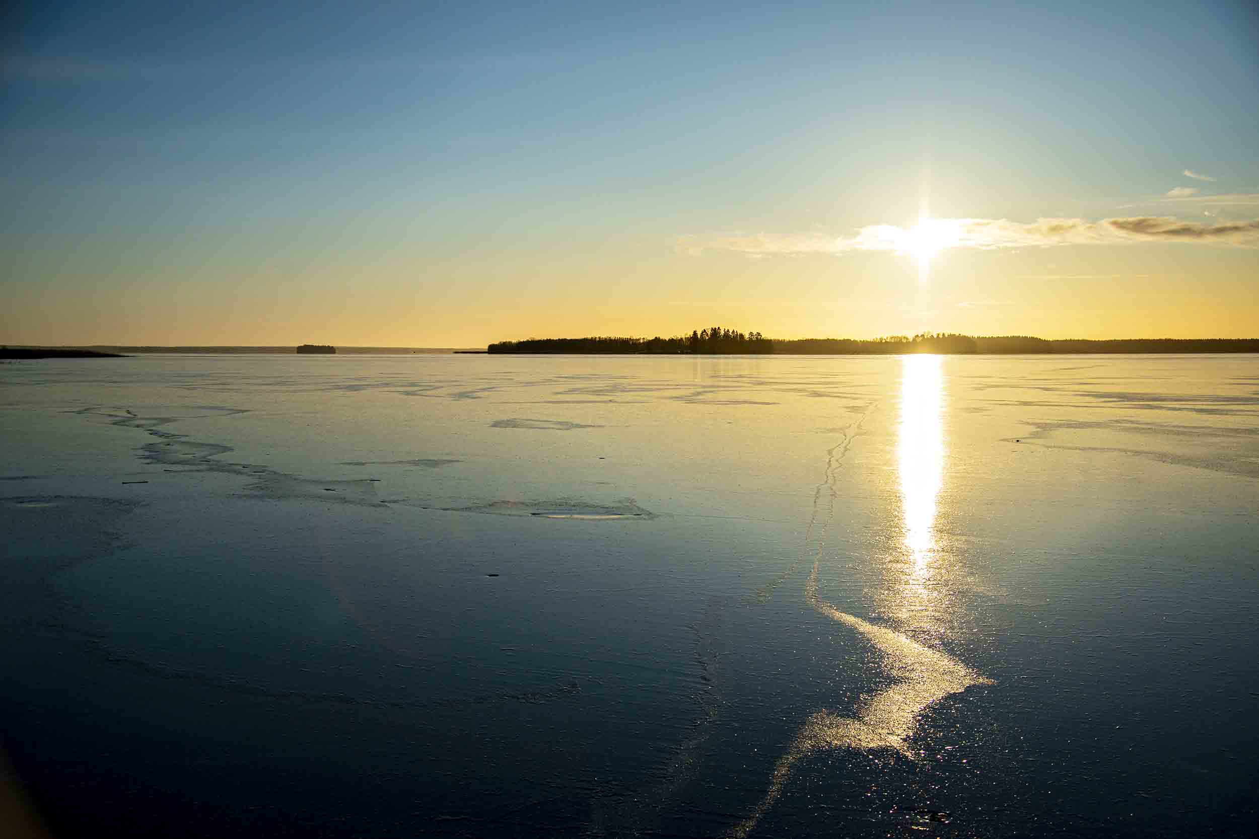 Vintersol som lyser över en frusen sjö