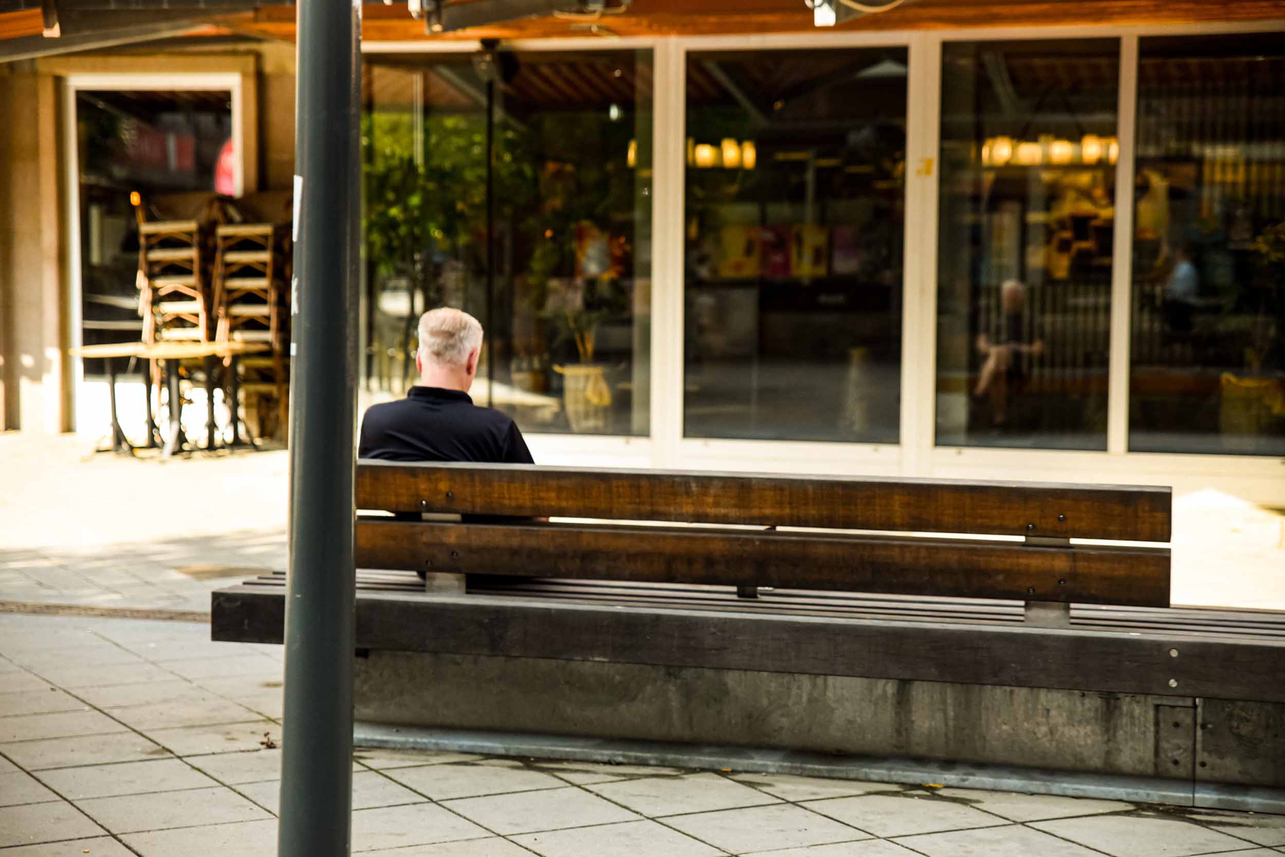 En person som sitter på en bänk vid gågatan i Sandvikens centrum